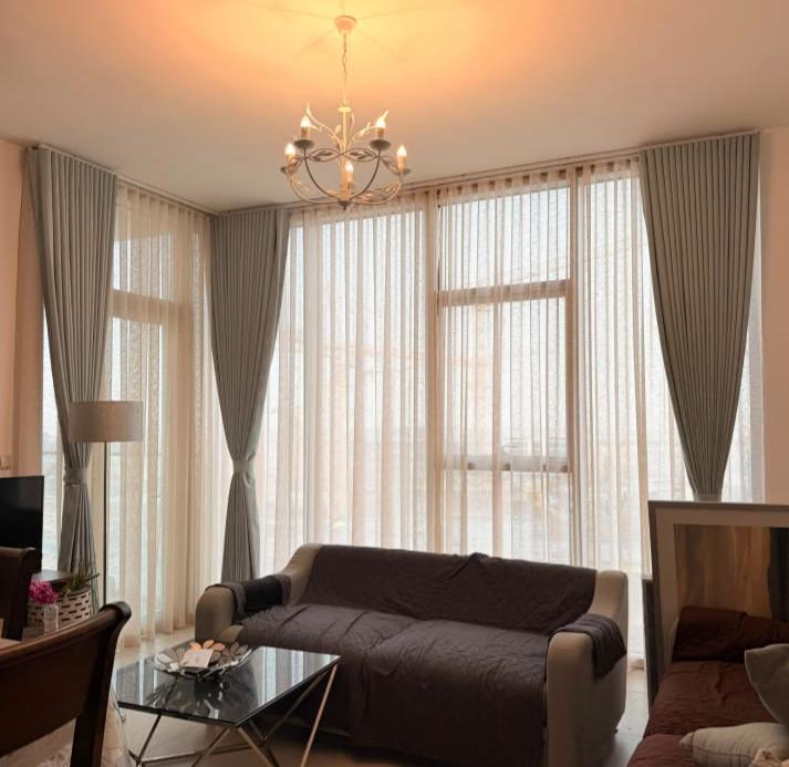 Sheer and blackout curtains with a pelmet in a living room