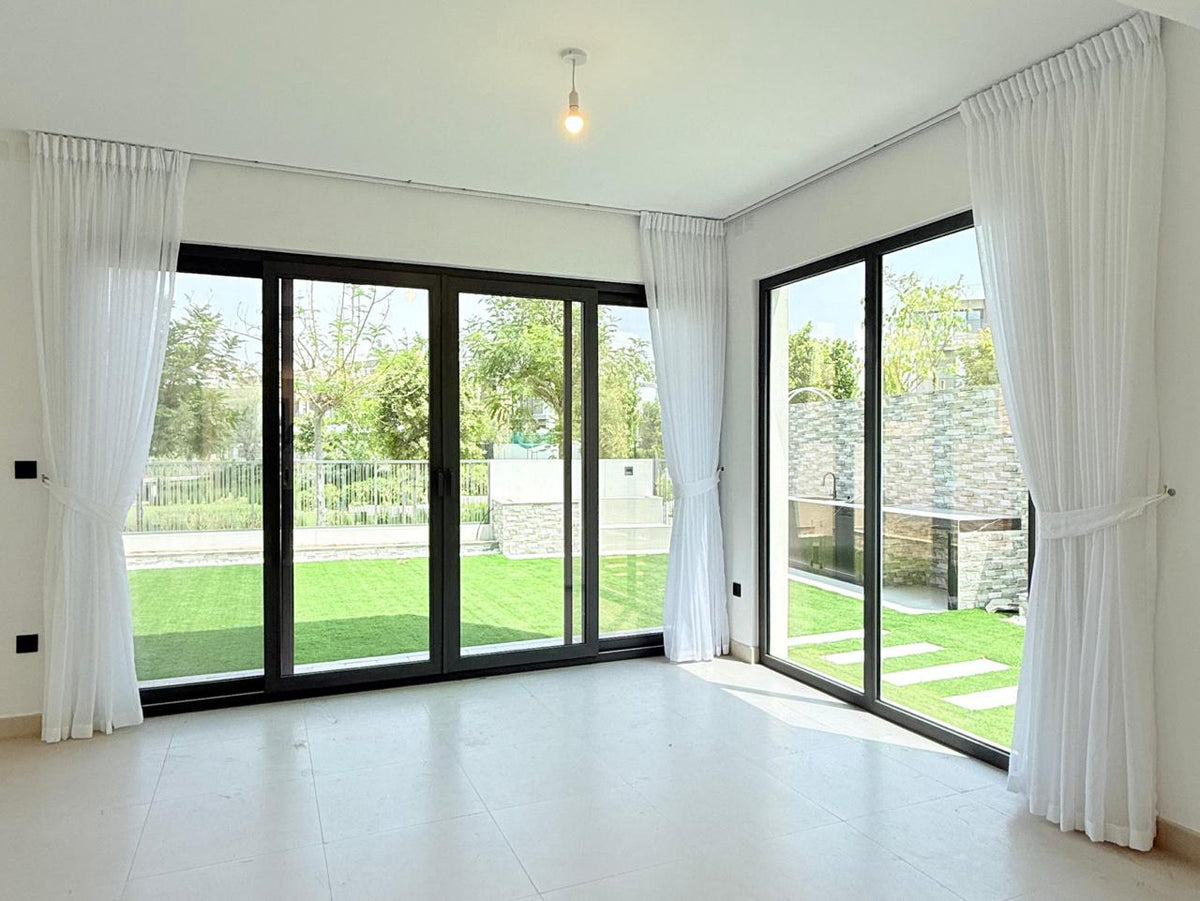 Sheer and side curtains at a floor-to-ceiling window in a home